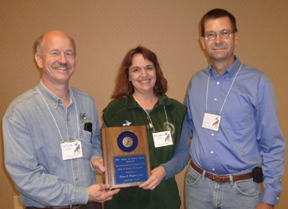 Steve and Regina Garr receiving award from Greg Beavers. Photo by Jim Rathert.